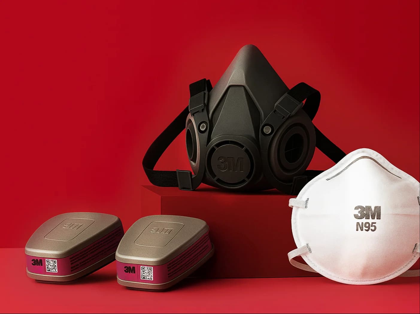Respirador 3M 6200, dos cartuchos 3M y una mascarilla 3M N95 sobre fondo rojo